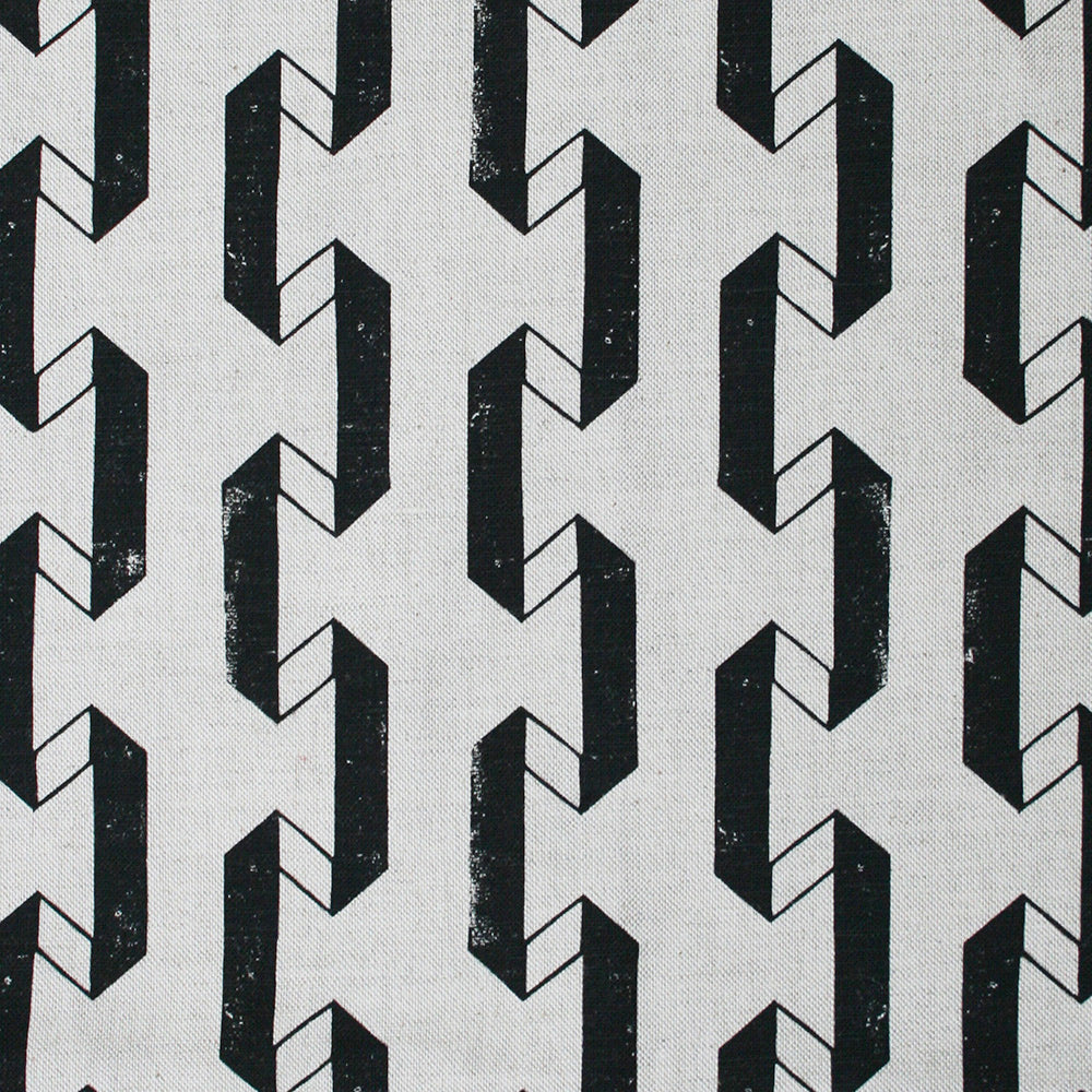 Detail of fabric in a geometric stripe print in black on a white field.