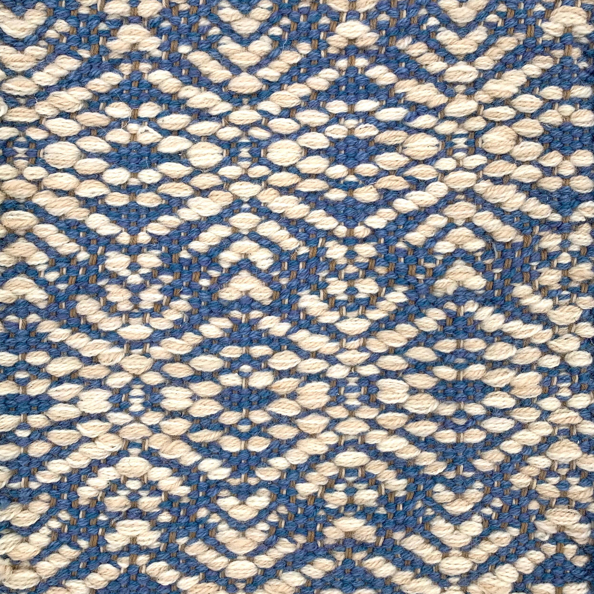 Handwoven rug detail in a contemporary design in blue and cream