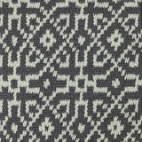 Close-up of a textured rug with a geometric pattern in turquoise on black