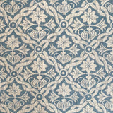 Detail of fabric in a floral lattice print in cream on a light blue field.