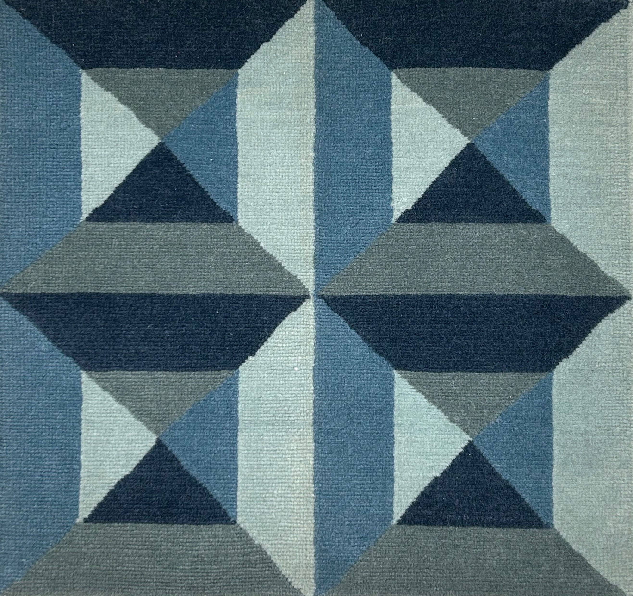 Geometric patterned rug with blue and gray triangles