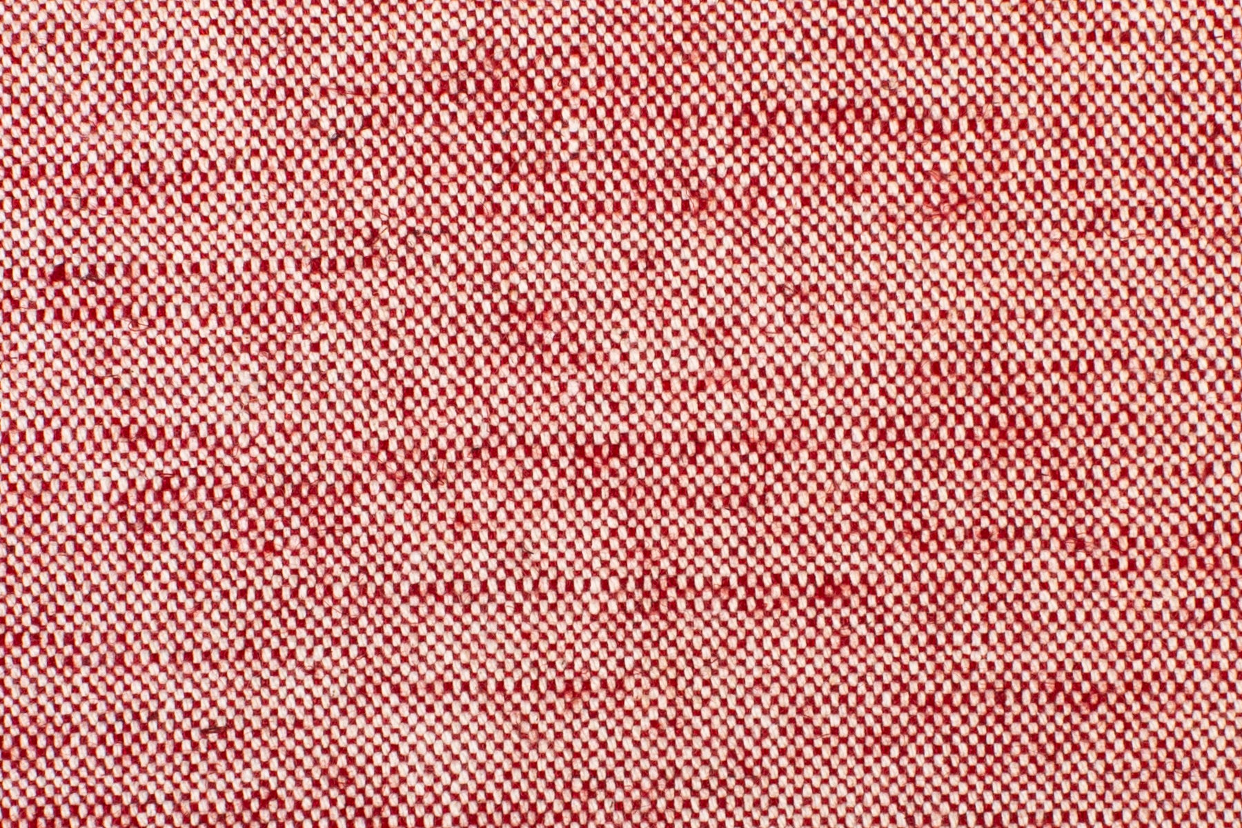 Detail of woven fabric yardage in textured cream and red.