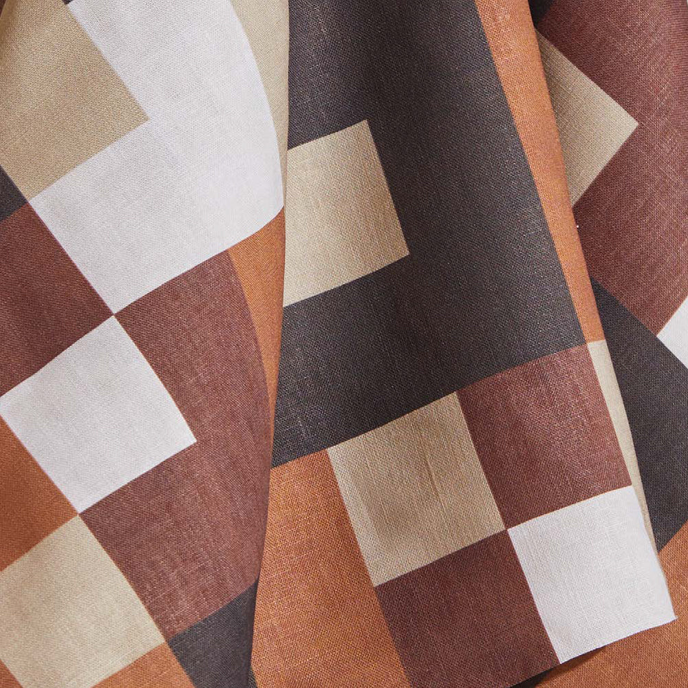 Draped fabric yardage in an interlocking square pattern in shades of brown, rust and cream.