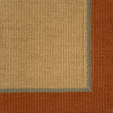 Close up of a flatweave rug in tan with a blue and coral border. 