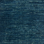 Textured handwoven carpet in teal blue.