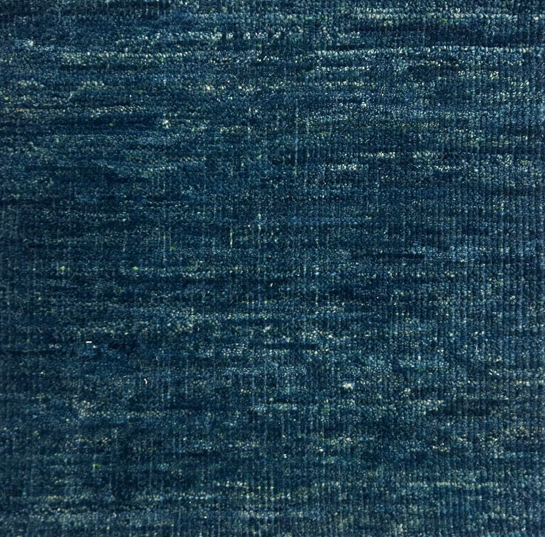 Textured handwoven carpet in teal blue.
