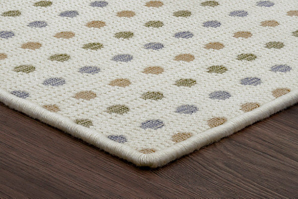 Close-up of a textured rug with a pattern on a wooden floor