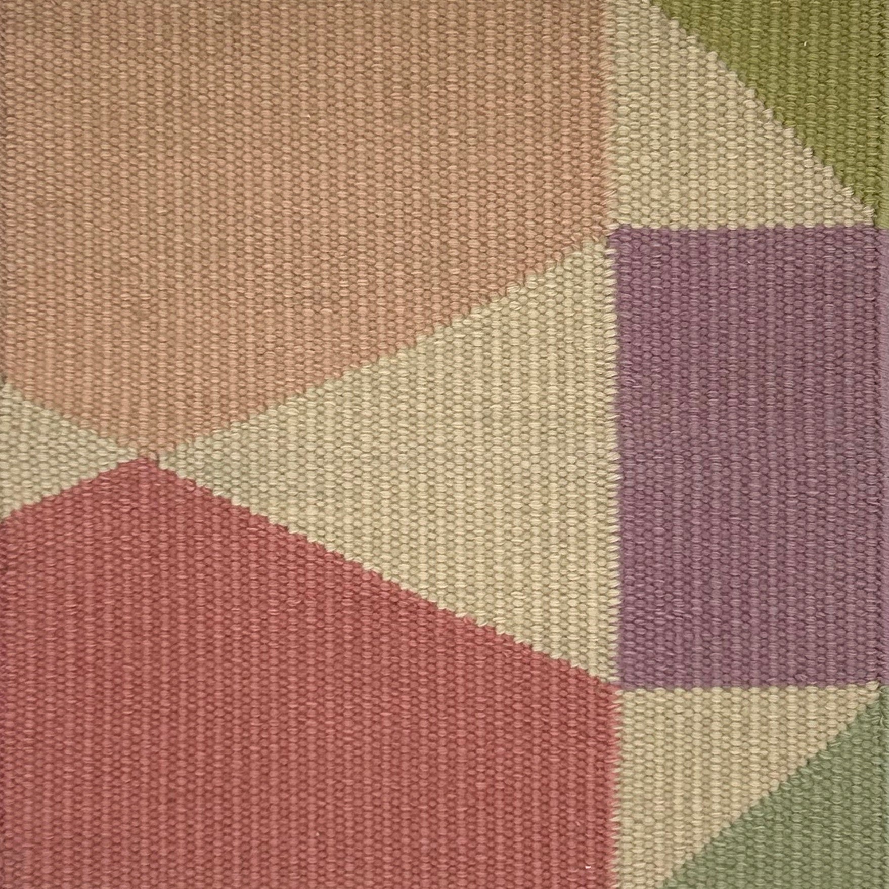 Geometric patterned rug with hexagonal and square shapes in various pastel colors.