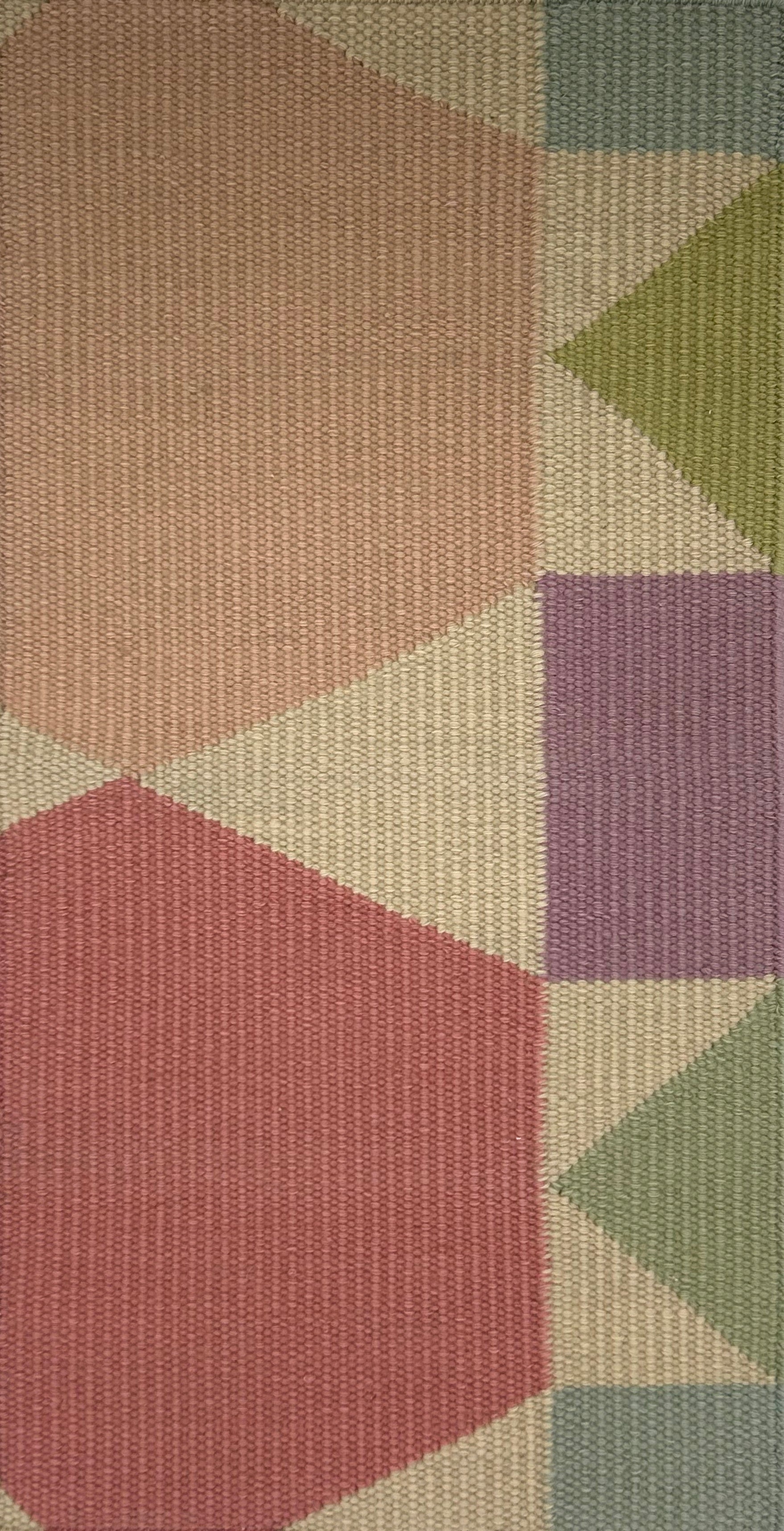 Geometric patterned rug with hexagonal and square shapes in various pastel colors.