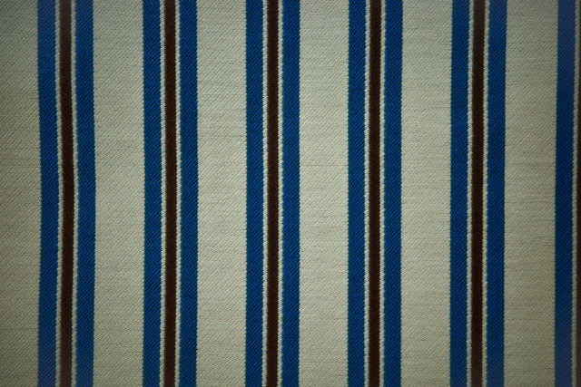 Striped fabric with blue and black vertical stripes on a neutral background