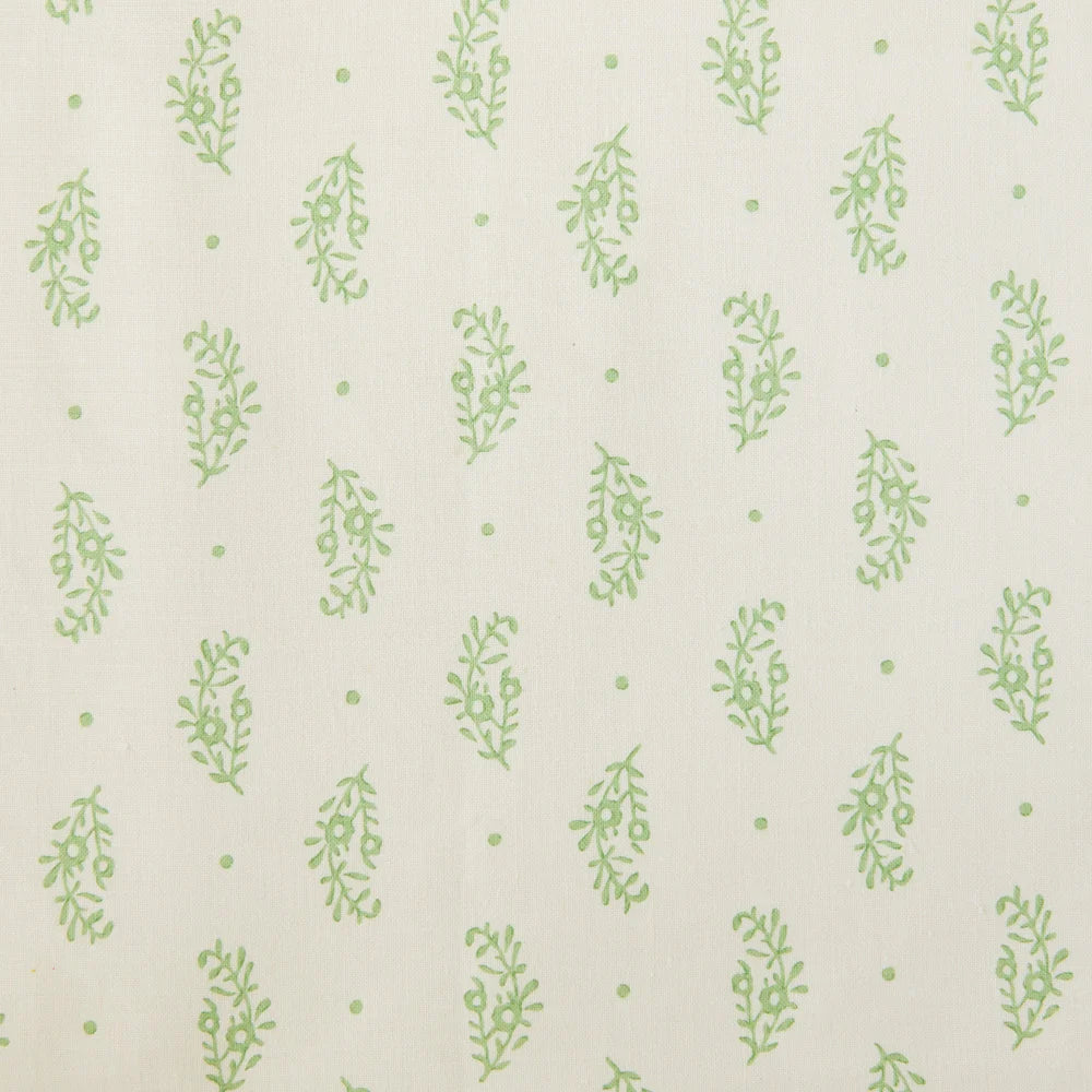 Detail of fabric in a floral paisley print in green on a cream field.