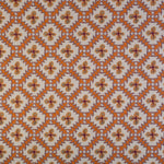 Detail of fabric in a playful floral grid print in orange, purple and green on a white field.