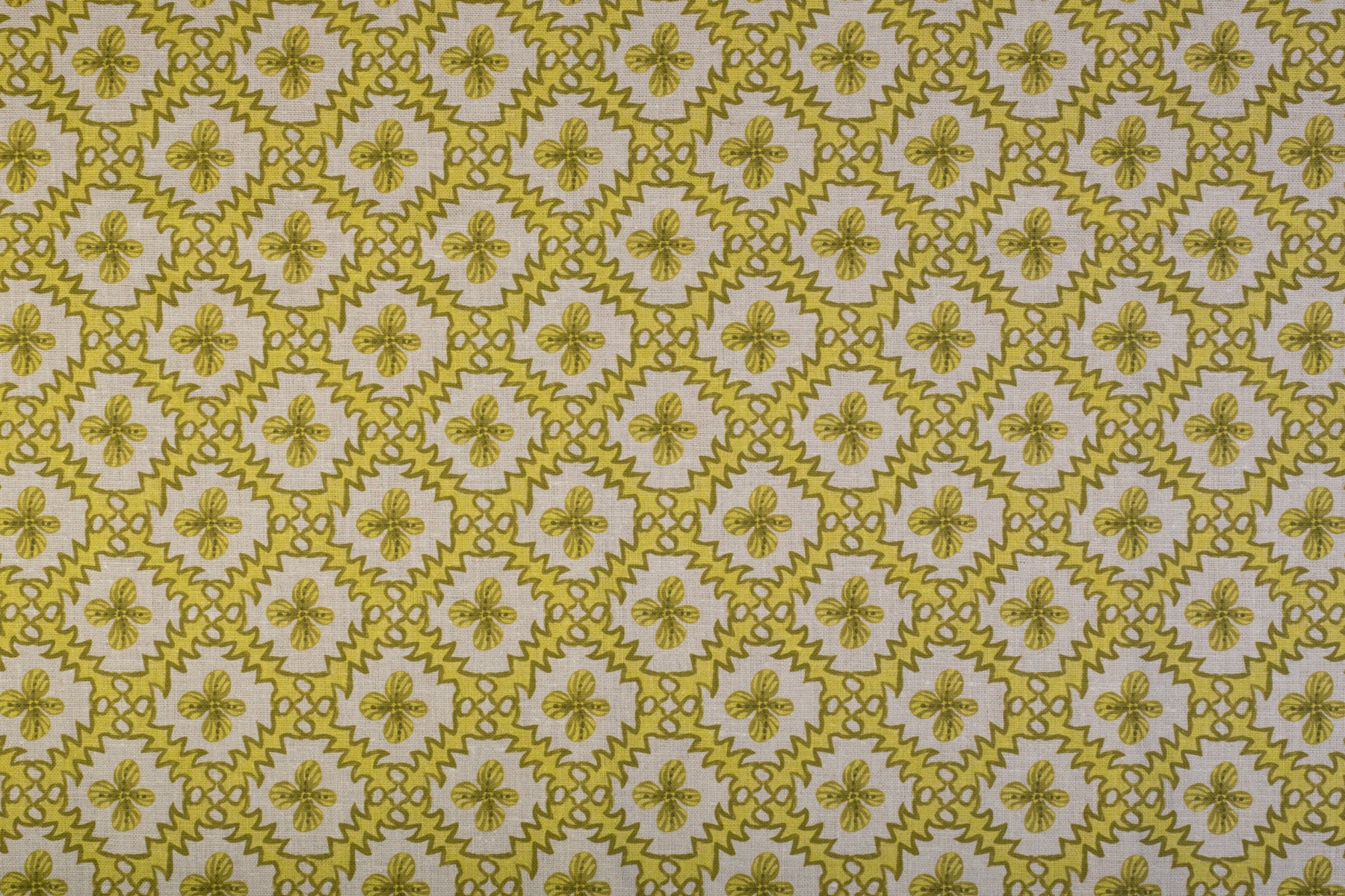 Detail of fabric in a playful floral grid print in yellow and brown on a white field.