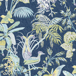 Detail of wallpaper in a dense bird and botanical print in shades of yellow and blue on a navy field.