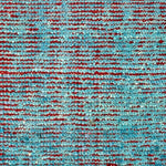 Detail of a hand knotted rug with teal and red woven together.