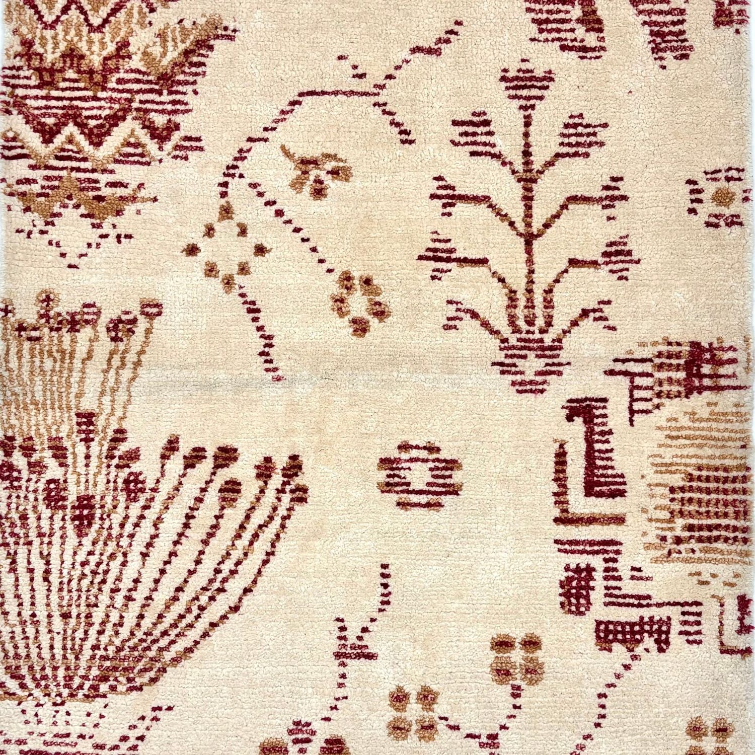 Detail of rug with an ivory background and dark red and gold gforal pattern