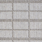 Broadloom carpet detail in plaid grid in shades of brown on a beige field.