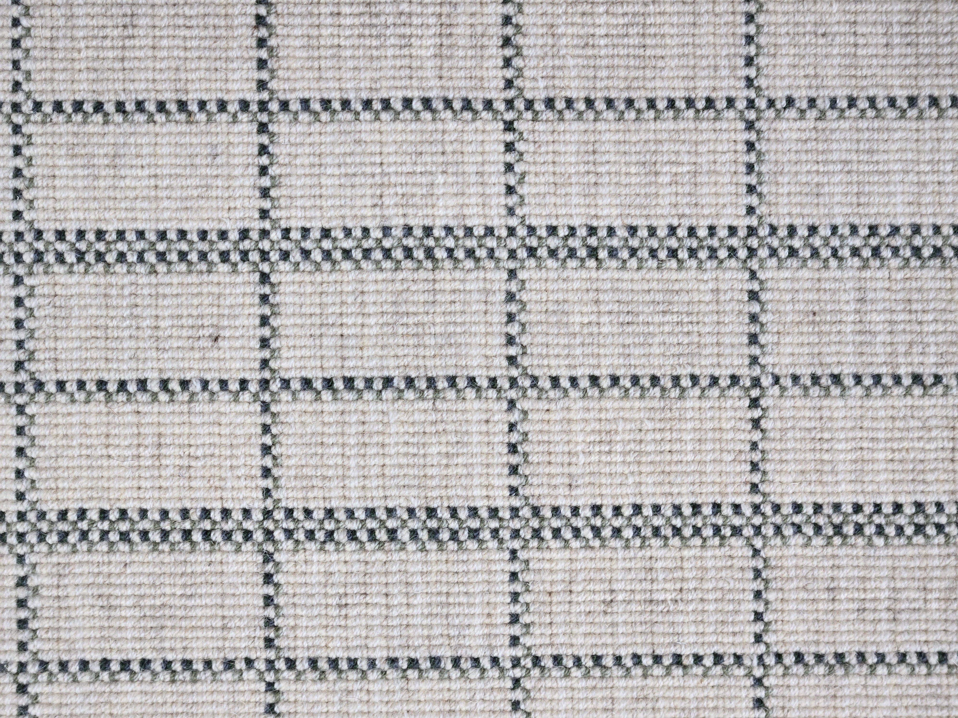 Broadloom carpet detail in plaid grid in shades of green on a beige field.