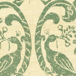 Detail of fabric in a botanical and bird print in dark turquoise on a cream field.