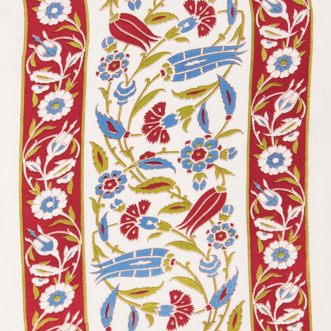 Detail of fabric in a floral stripe print in blue, red and yellow on a white field.