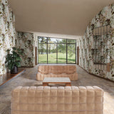 Modern living room with beige sofas and a large window overlooking greenery.