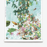 Roll of wallpaper with a floral and leaf pattern on a light blue background