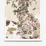 Roll of wallpaper with floral and leaf pattern on a beige background