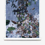 Roll of wallpaper with floral and abstract design on a blue grid background