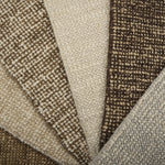 Close-up of textured carpet swatches in beige, brown, and gray.