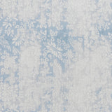 printed linen fabric in a floral and leaf pattern in white on a mottled blue and gray field.