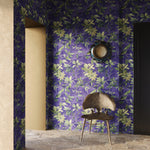 Room with purple floral wallpaper, a chair, and a mirror.