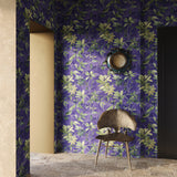 Room with purple floral wallpaper, a chair, and a mirror.