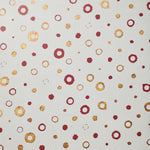 Detail of wallpaper in an irregular polka dot print in shades of gold and red on a white field.