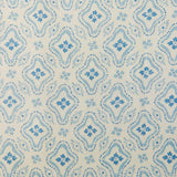 Detail of fabric in a painterly damask print in blue on a cream field.