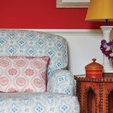 An upholstered armchair and throw pillow, both in floral prints in two different colorways.