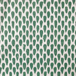 Detail of fabric in a painterly teardrop print in green on a white field.