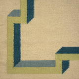 Close-up of a geometric patterned rug with green and blue lines on a beige background