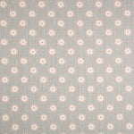 Detail of fabric in a playful dot print in pink and cream on a gray field.