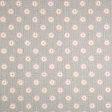 Detail of fabric in a playful dot print in pink and cream on a gray field.