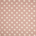 Detail of fabric in a playful dot print in gray and white on a mauve field.