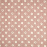 Detail of fabric in a playful dot print in gray and white on a mauve field.