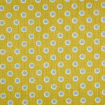 Detail of fabric in a playful dot print in blue and white on a mustard field.