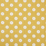 Detail of fabric in a playful dot print in white and gray on a mustard field.