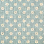 Detail of fabric in a playful dot print in white, gray and tan on a blue field.