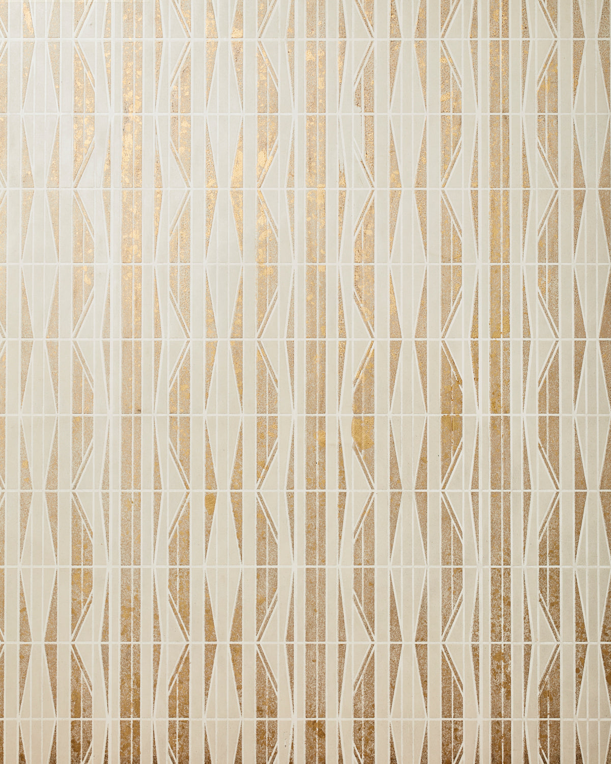 Detail of wallpaper in a geometric grid print in metallic gold, cream and white.