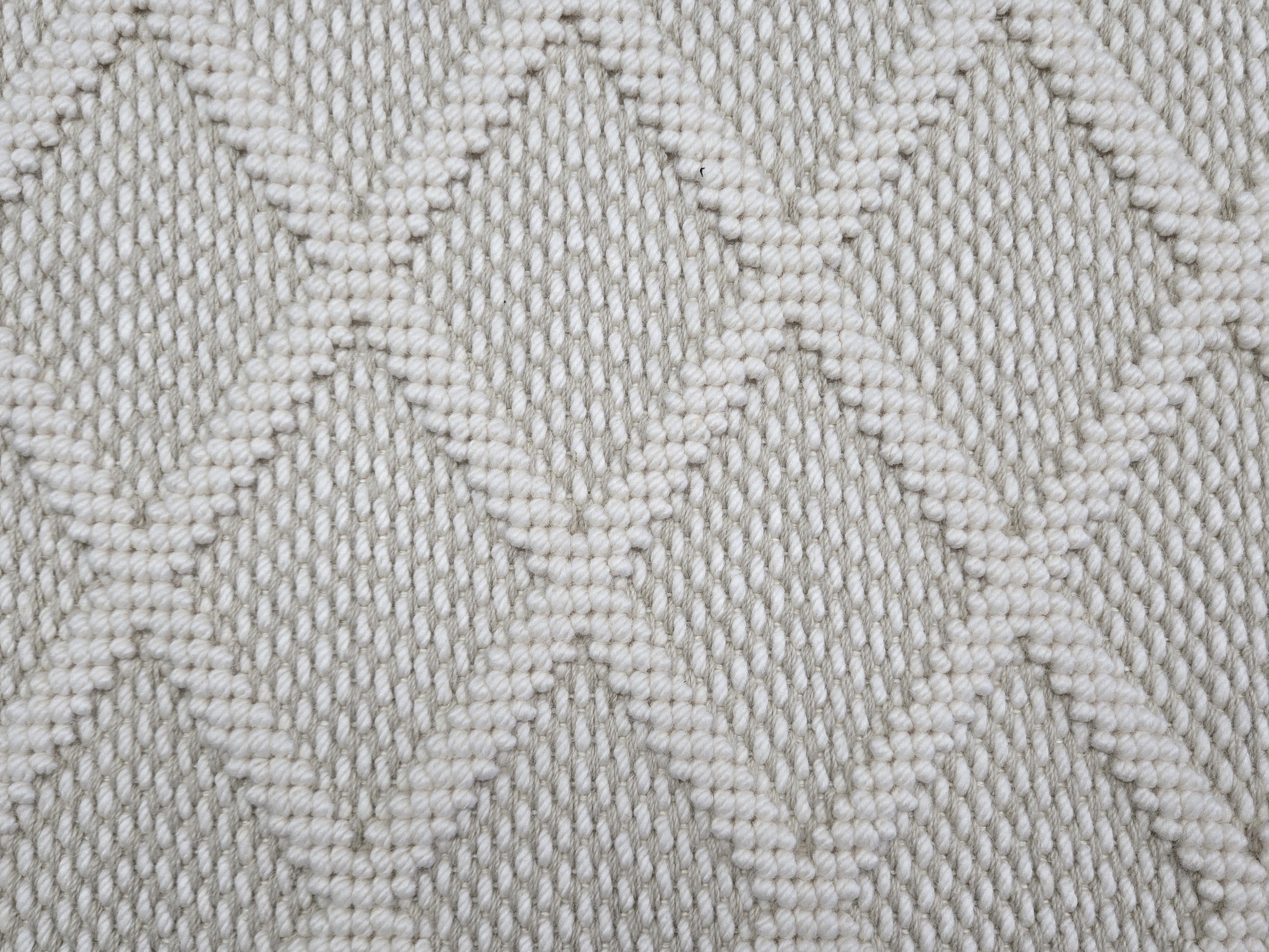 Broadloom carpet in a dimension diamond lattice in cream and taupe. 