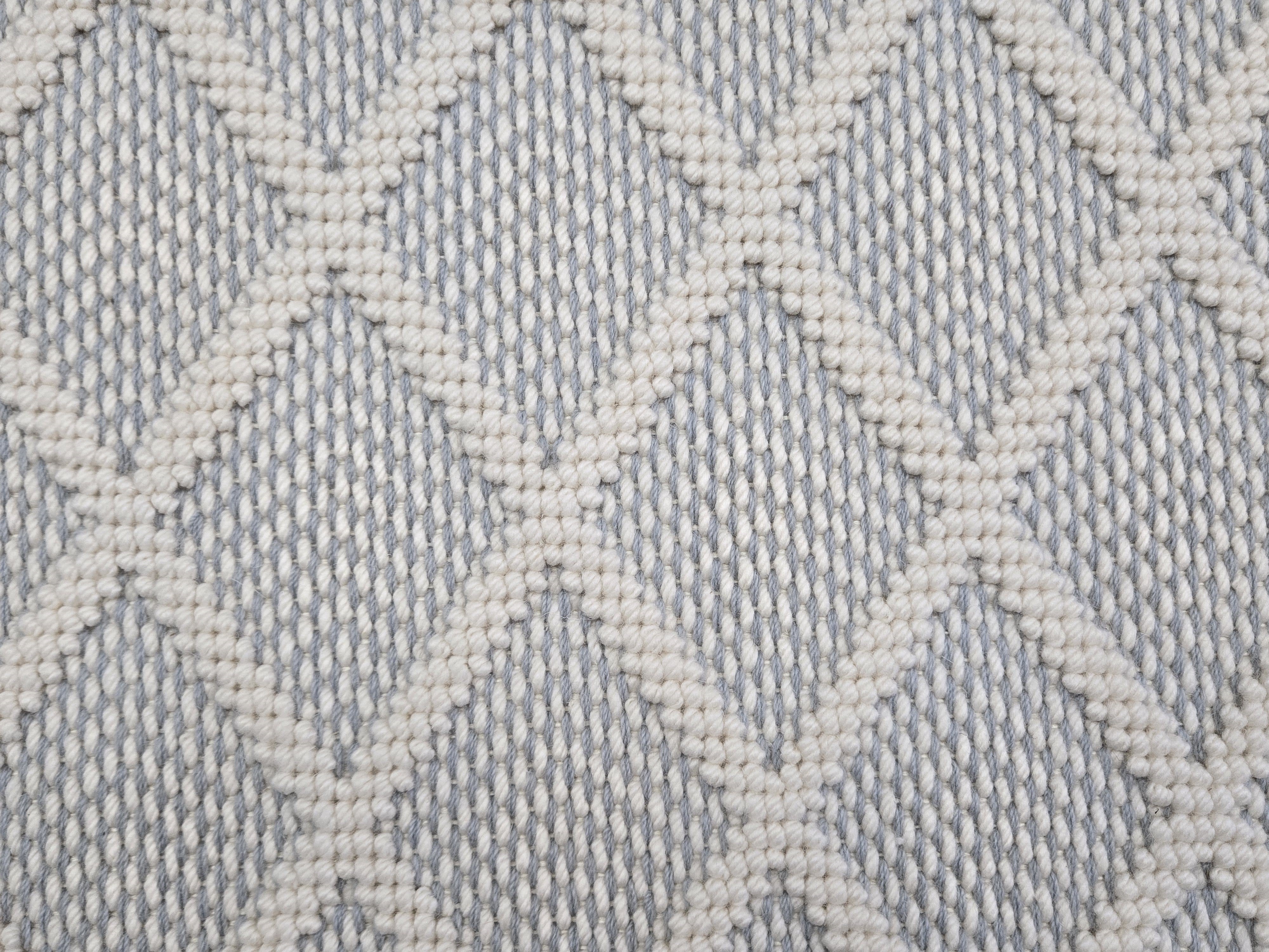 Broadloom carpet in a dimension diamond lattice in cream and slate blue.