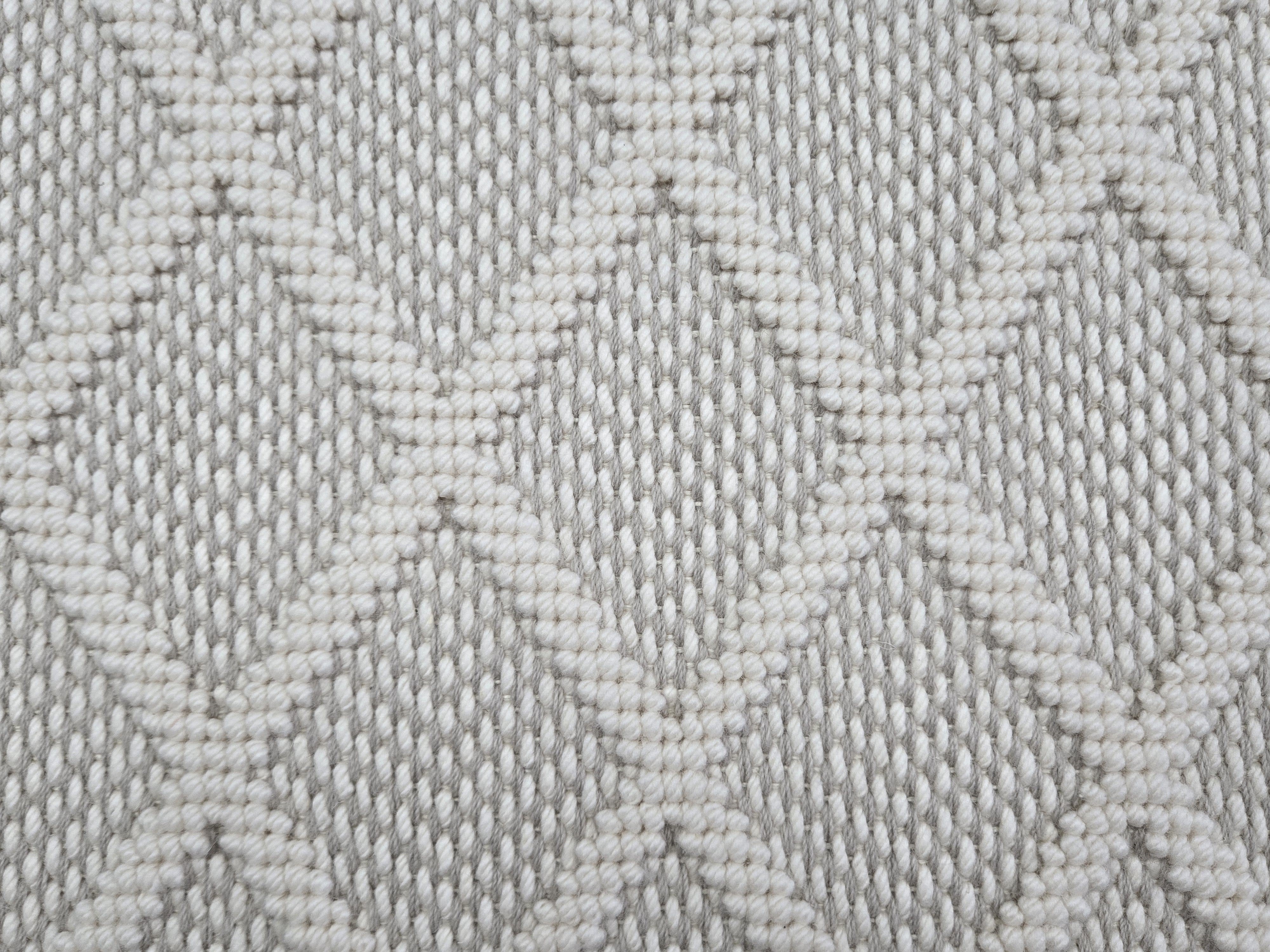 Broadloom carpet in a dimension diamond lattice in cream and warm grey.