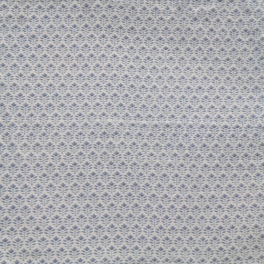 Detail of fabric in a small-scale floral grid print in blue on a cream field.