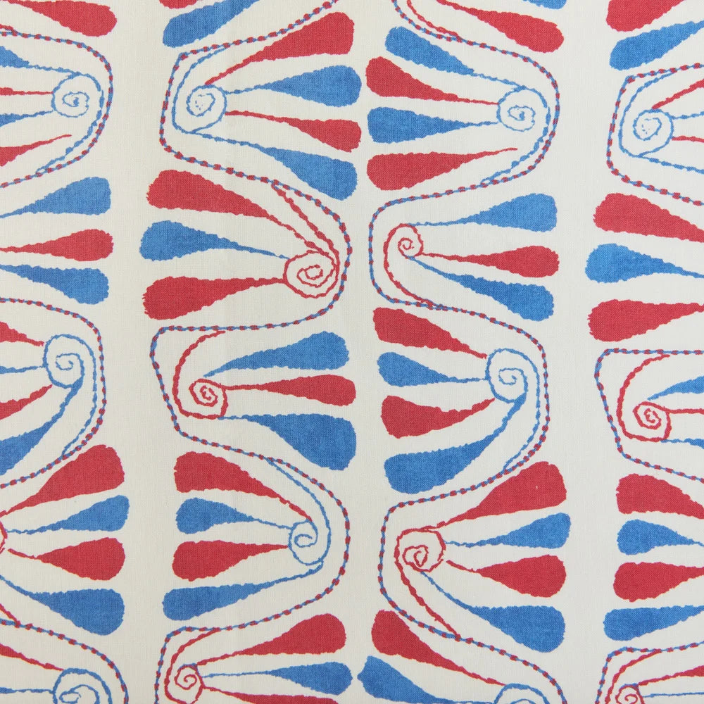 Detail of fabric in an abstract floral stripe in red and blue on a cream field.